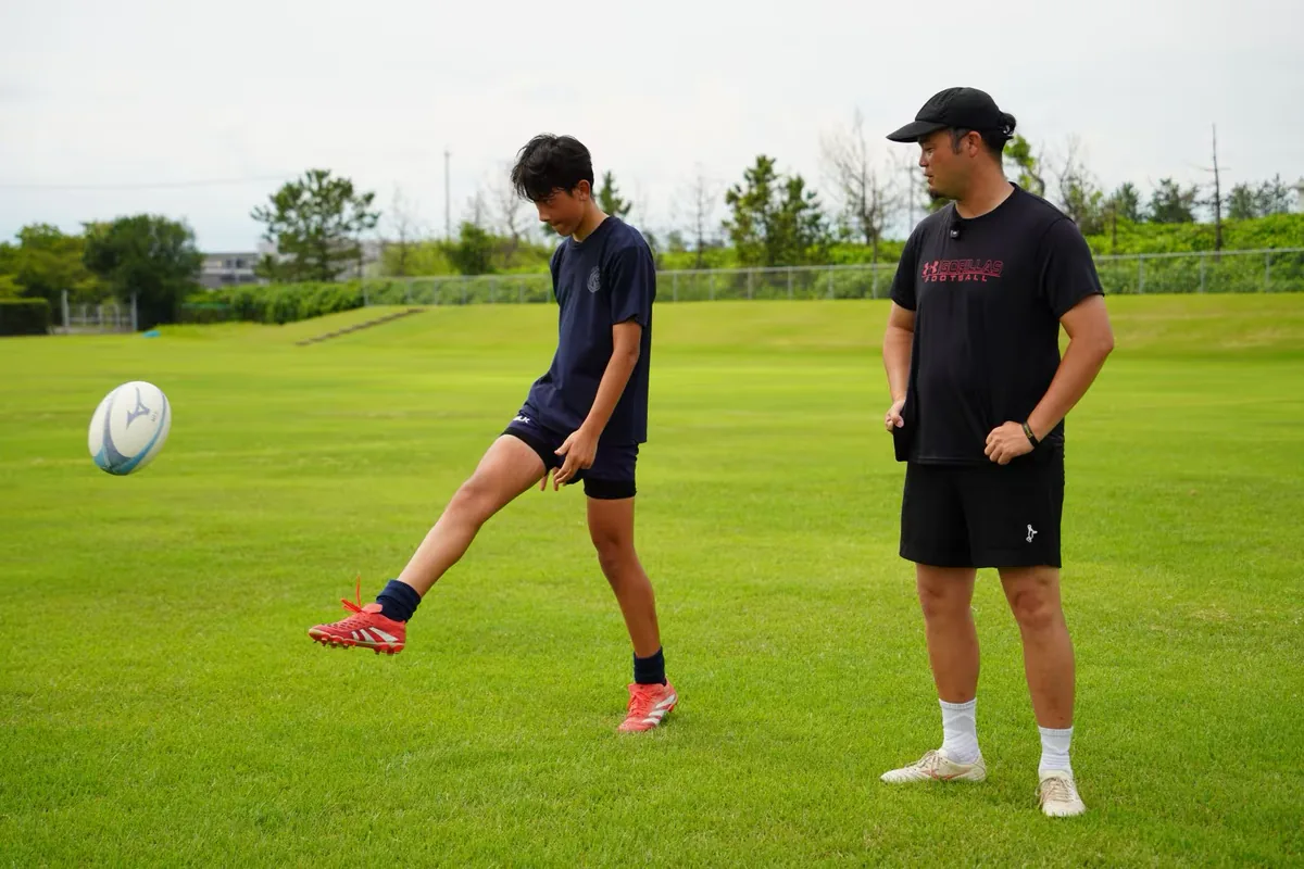グラウンドで選手のキックを指導する丸田喬仁コーチ