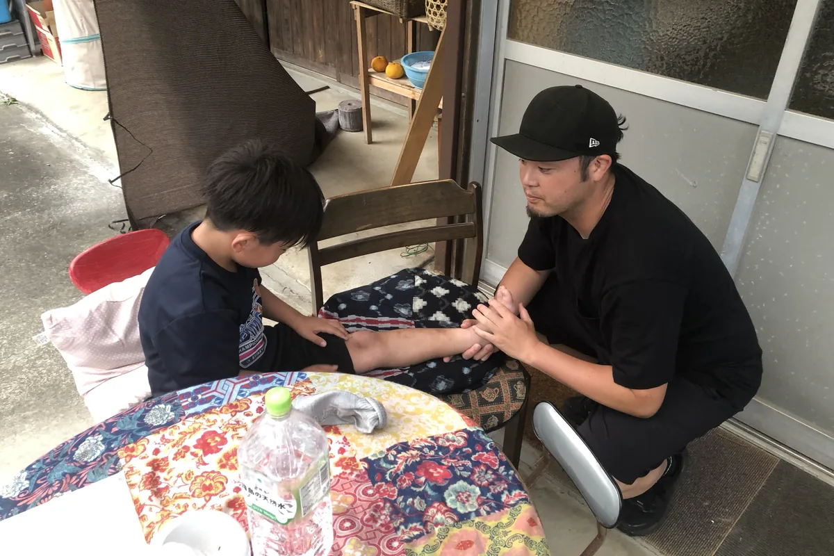 選手の脚を施術する丸田喬仁コーチ