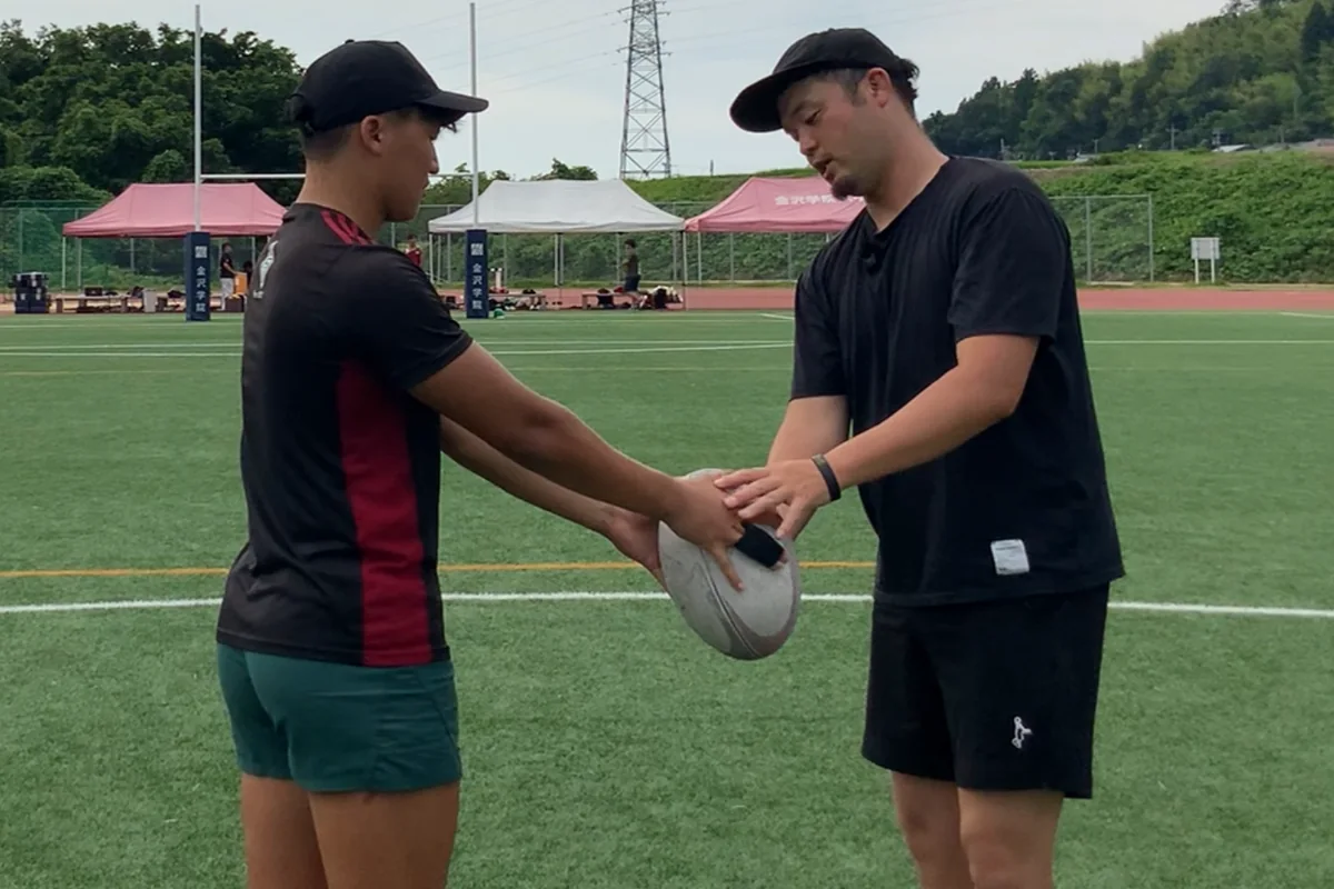 グラウンドで、選手にボールの持ち方を指導するキックコーチ 丸田喬仁