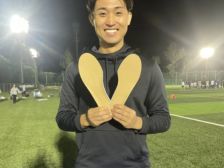 ナイター照明の下でインソールを手にする選手